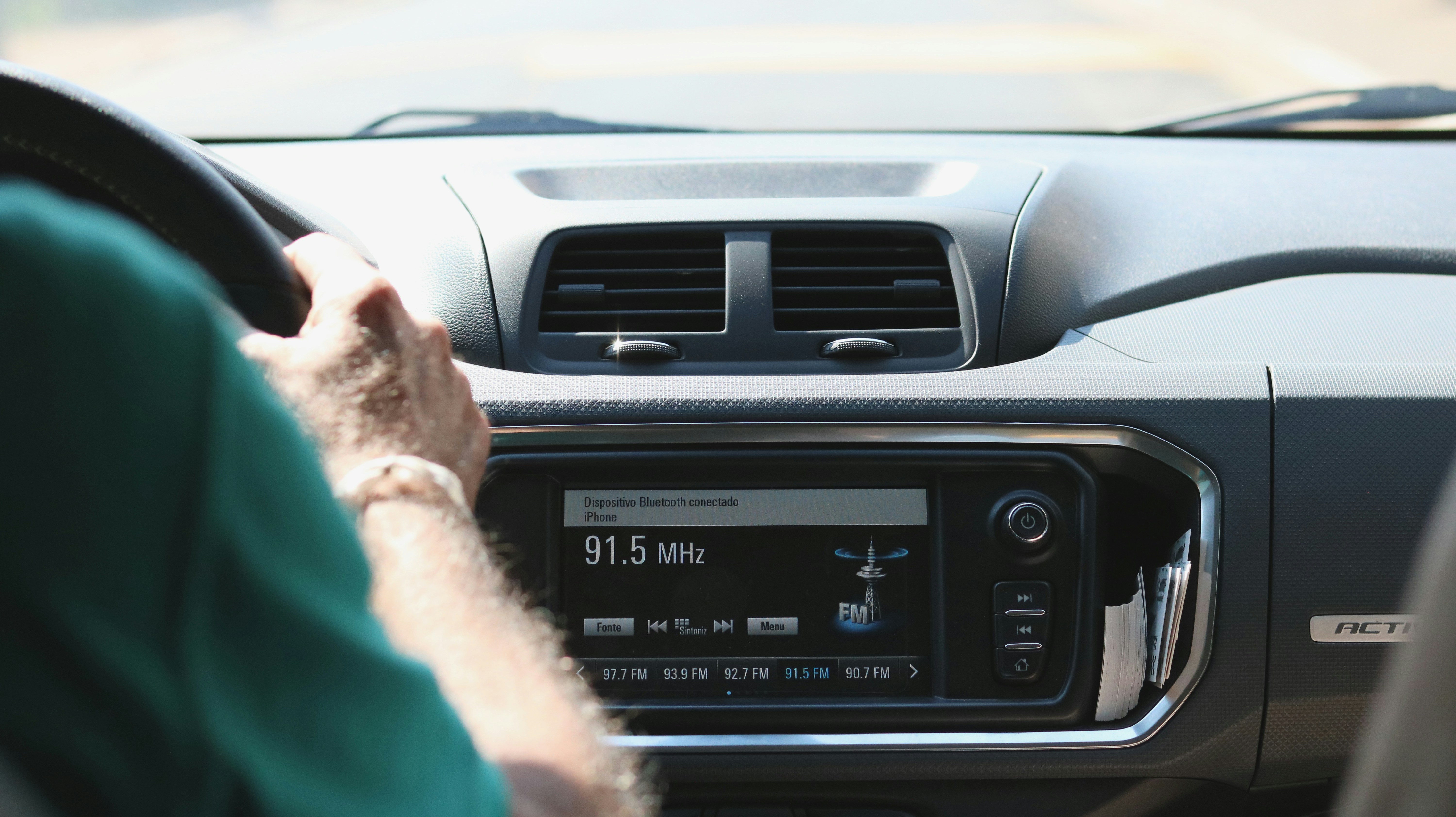 Person adjusting car radio dashboard
